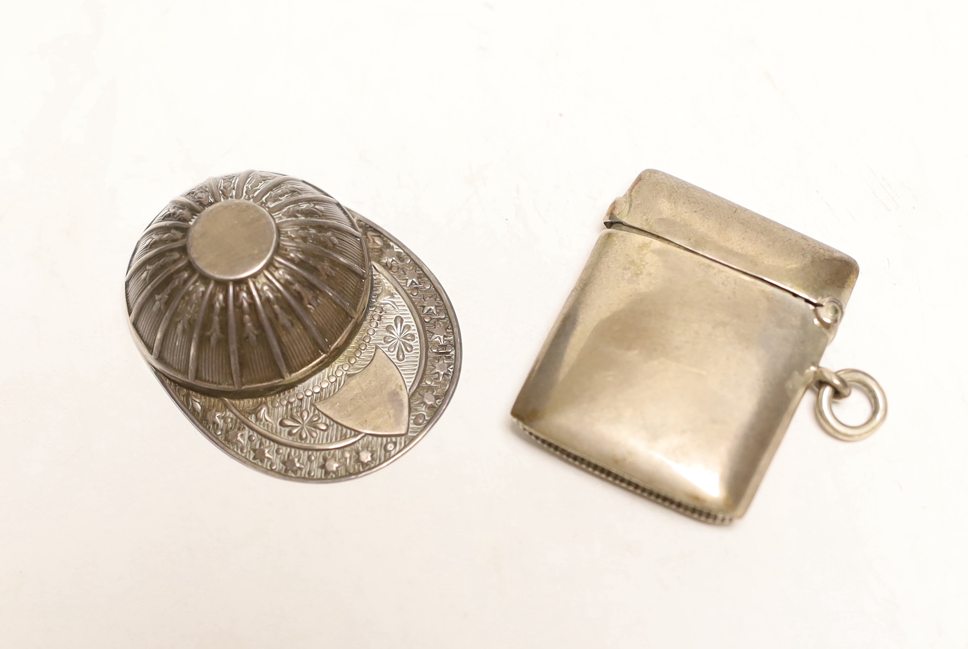 An Elizabeth II silver jockey cap caddy spoon, Francis Howard Ltd, Sheffield, 1973, 52mm and and an Edwardian silver vesta case.